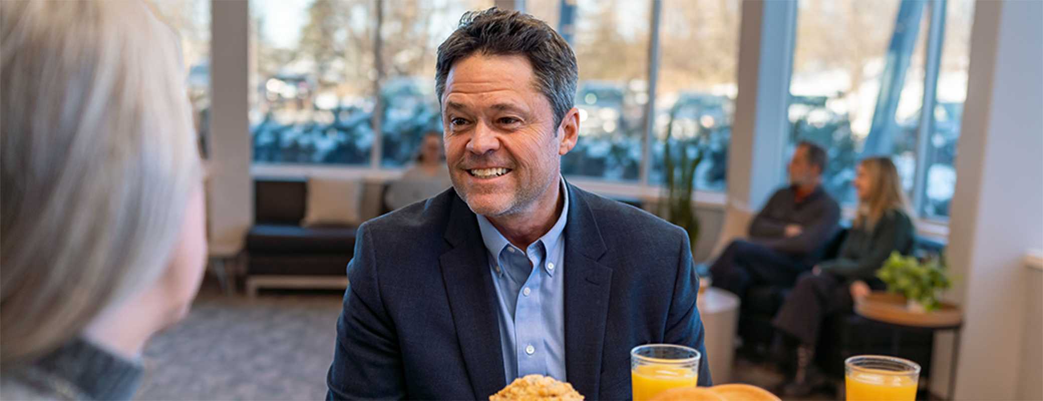Image of Justin Osmond sharing beverages with another person in a cafe setting